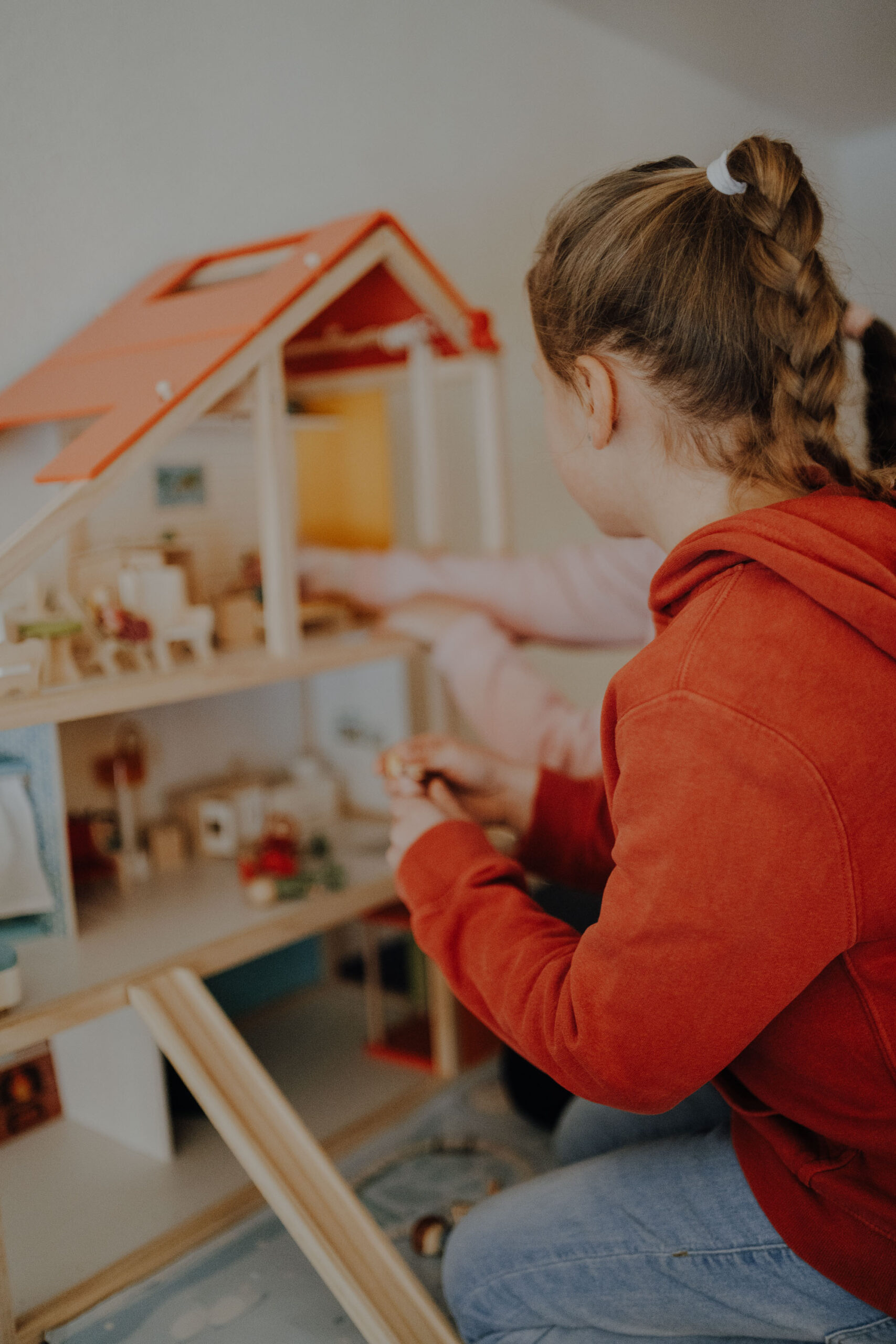 Kinder spielen mit Puppenhaus